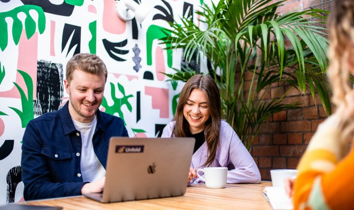 Izzy, Unfold's UX designer and Harry, Managing Director at Unfold are sitting in a meeting room looking at a laptop